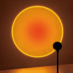 Lampe noire projetant un cercle de lumière orangée sur un mur.