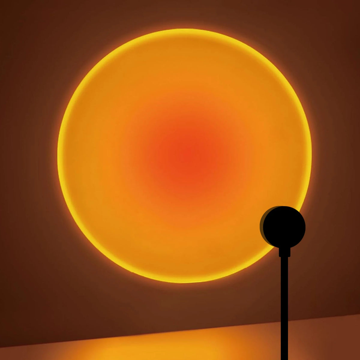 Lampe noire projetant un cercle de lumière orangée sur un mur.