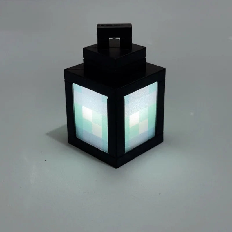 Lanterne Pixelia Mini noire diffusant une lumière blanche sur fond gris.
