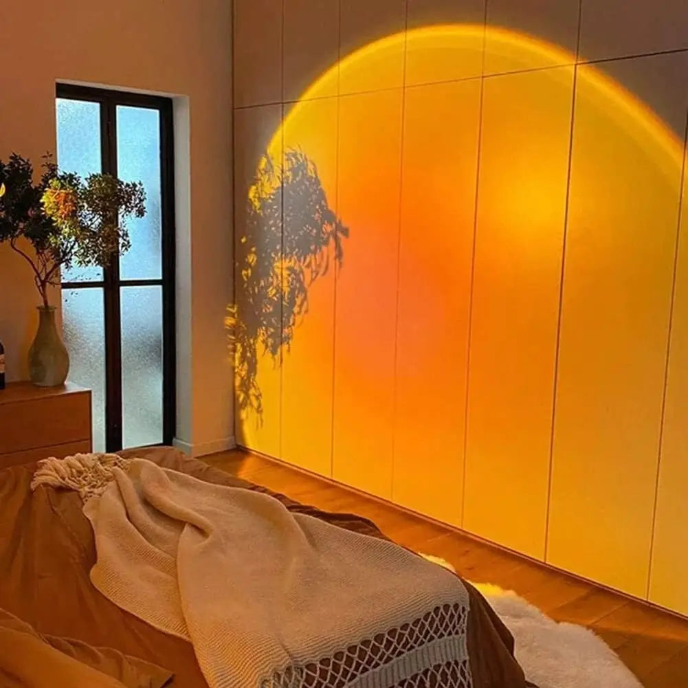 Grande projection lumineuse orangée sur une armoire, avec l’ombre d’une plante.