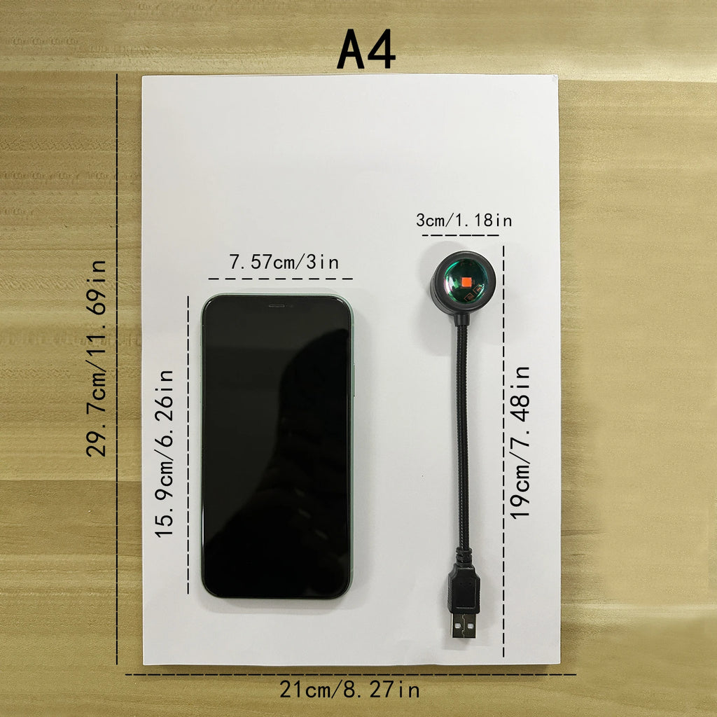 Lampe USB noire et téléphone posés sur une feuille A4, avec repères de dimensions.