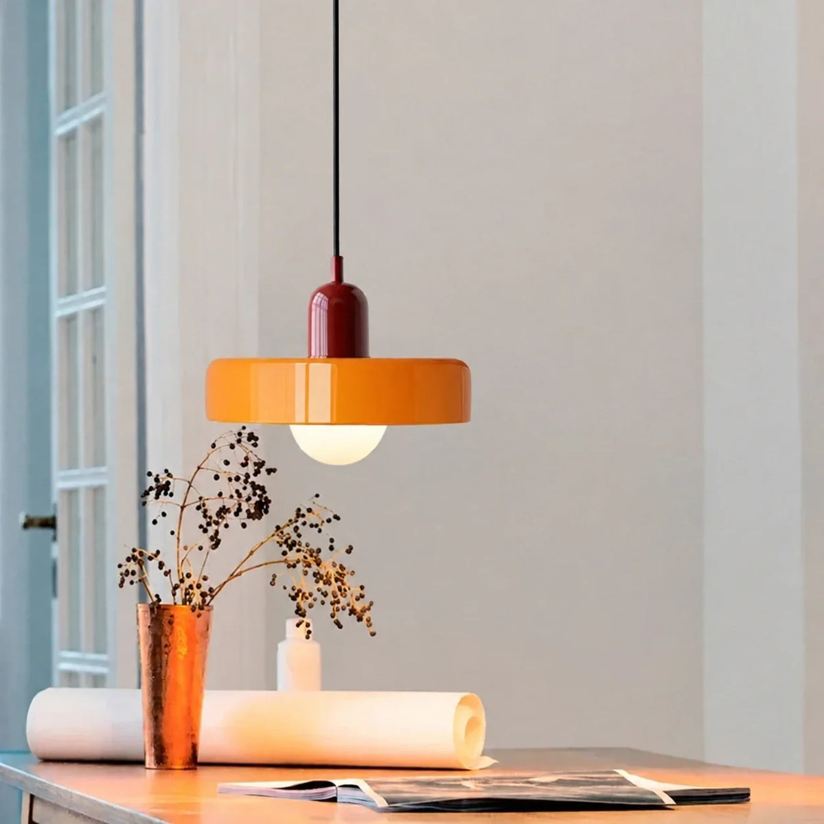 Sixties bordeaux et orange — suspension en verre au-dessus d’une table.