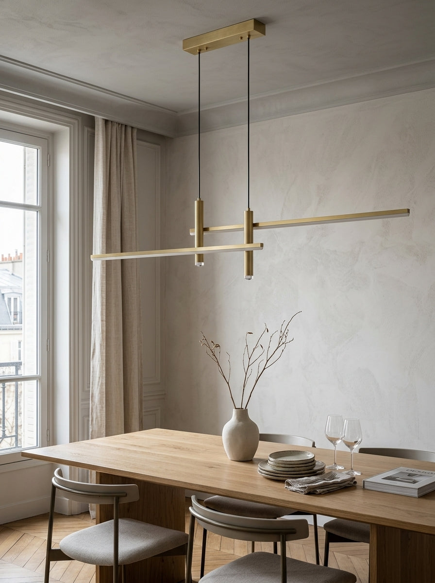 Suspension Linéva Or Champagne au-dessus d’une table dans une salle à manger lumineuse.