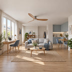 Alizé — ventilateur à trois pales claires et moteur argenté, dans un salon avec kitchenette bleue — mise en scène illustrative