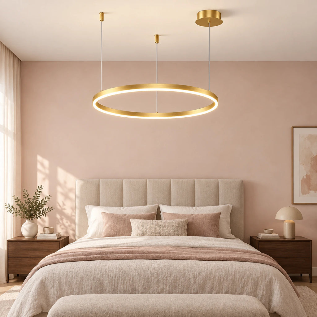 Suspension à un anneau doré dans une chambre aux tons roses.