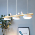 Aviara blanche — trois oiseaux sur structure en bois