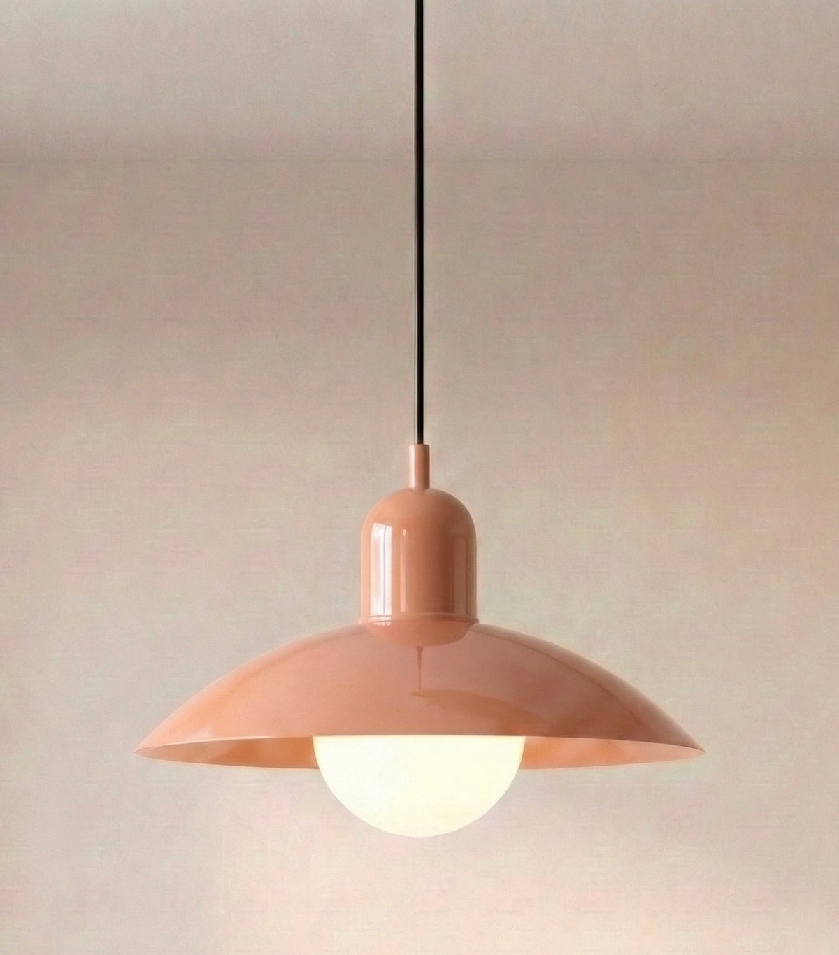 Caléria, abat-jour rose et col rose, avec câble noir et globe lumineux.