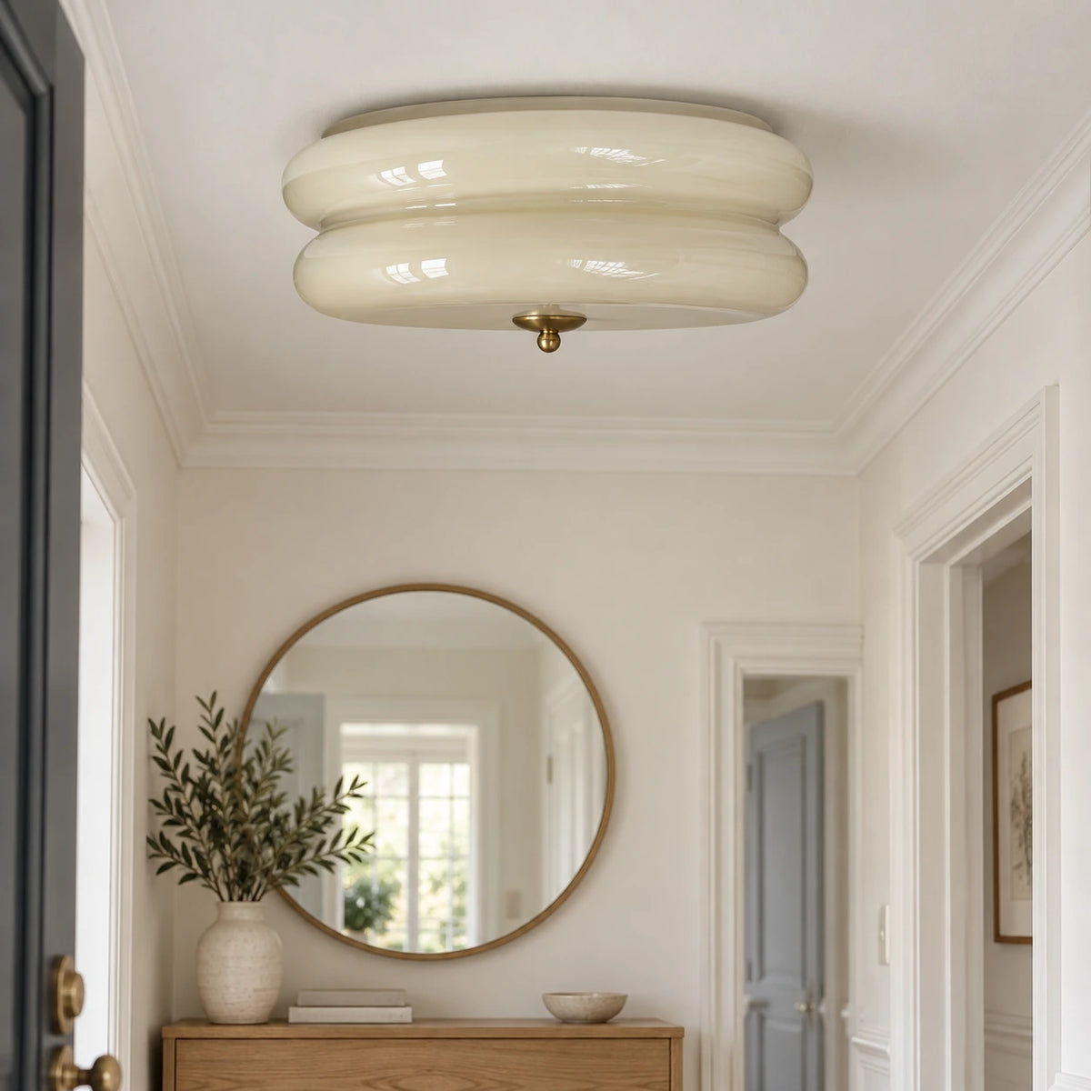 Ciselé beige et doré — plafonnier dans une entrée lumineuse.