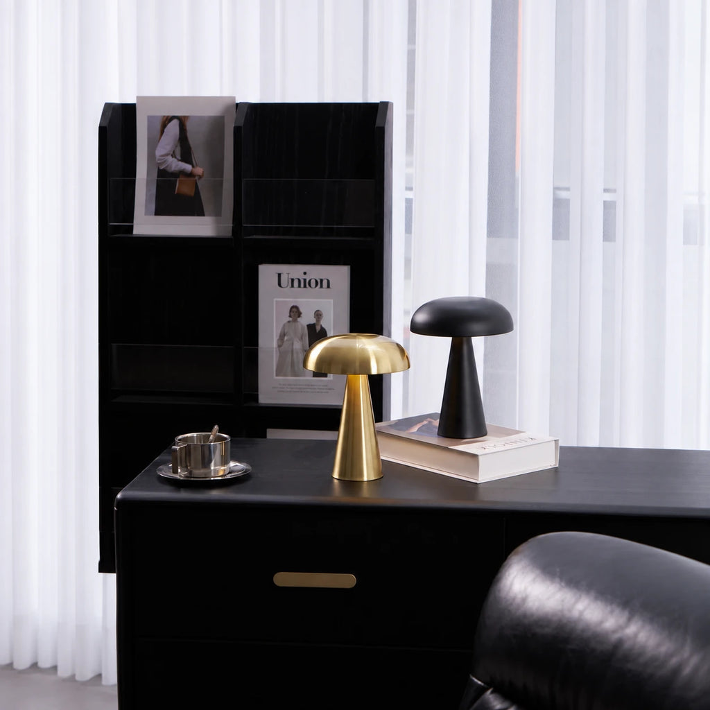 Galet — lampes dorée et noire à abat-jour arrondi et pied conique, disposées sur un bureau