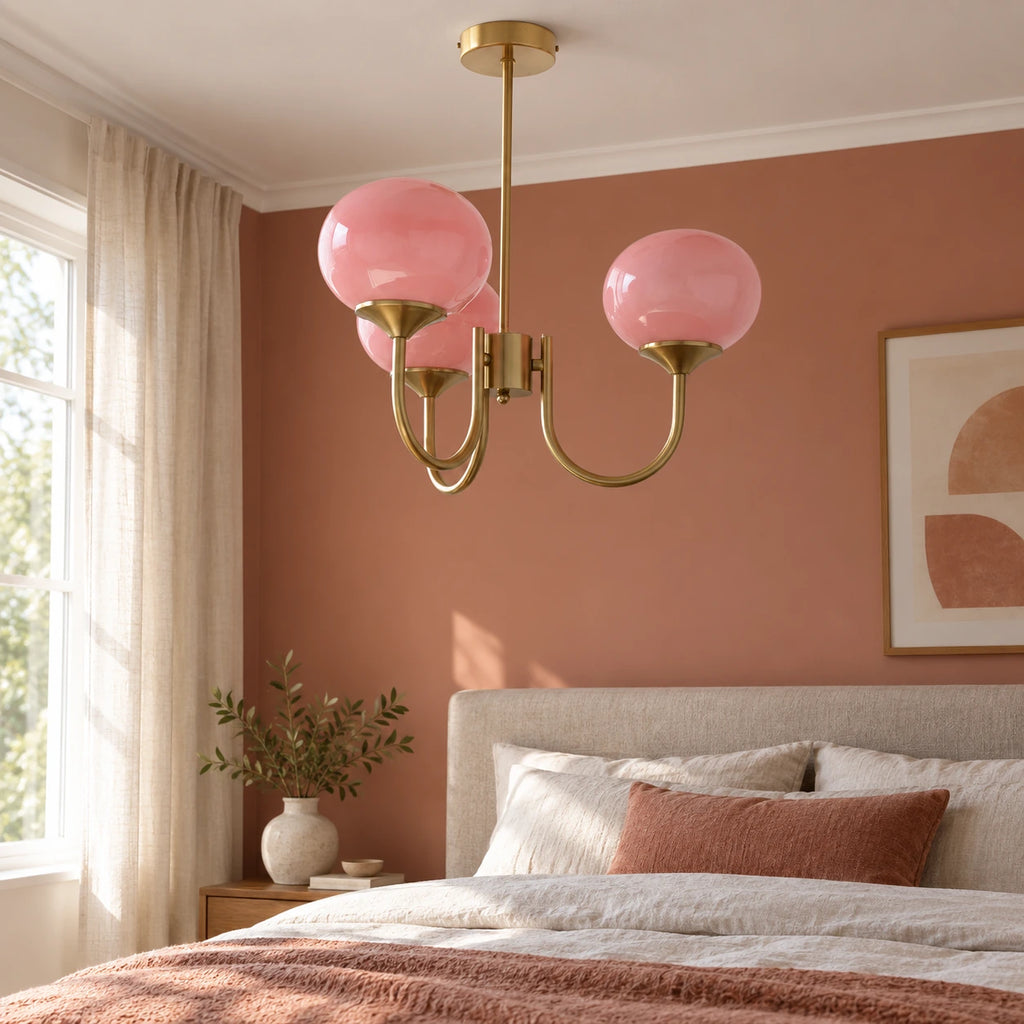 Guimauve rose et doré — lustre à trois globes dans une chambre.