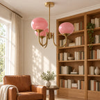 Guimauve à trois globes roses et structure dorée dans un coin bibliothèque. Décor non fourni.