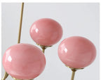 Détail des trois globes rose en verre et de la structure dorée de Guimauve