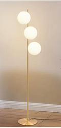 Lampadaire doré à trois globes blancs