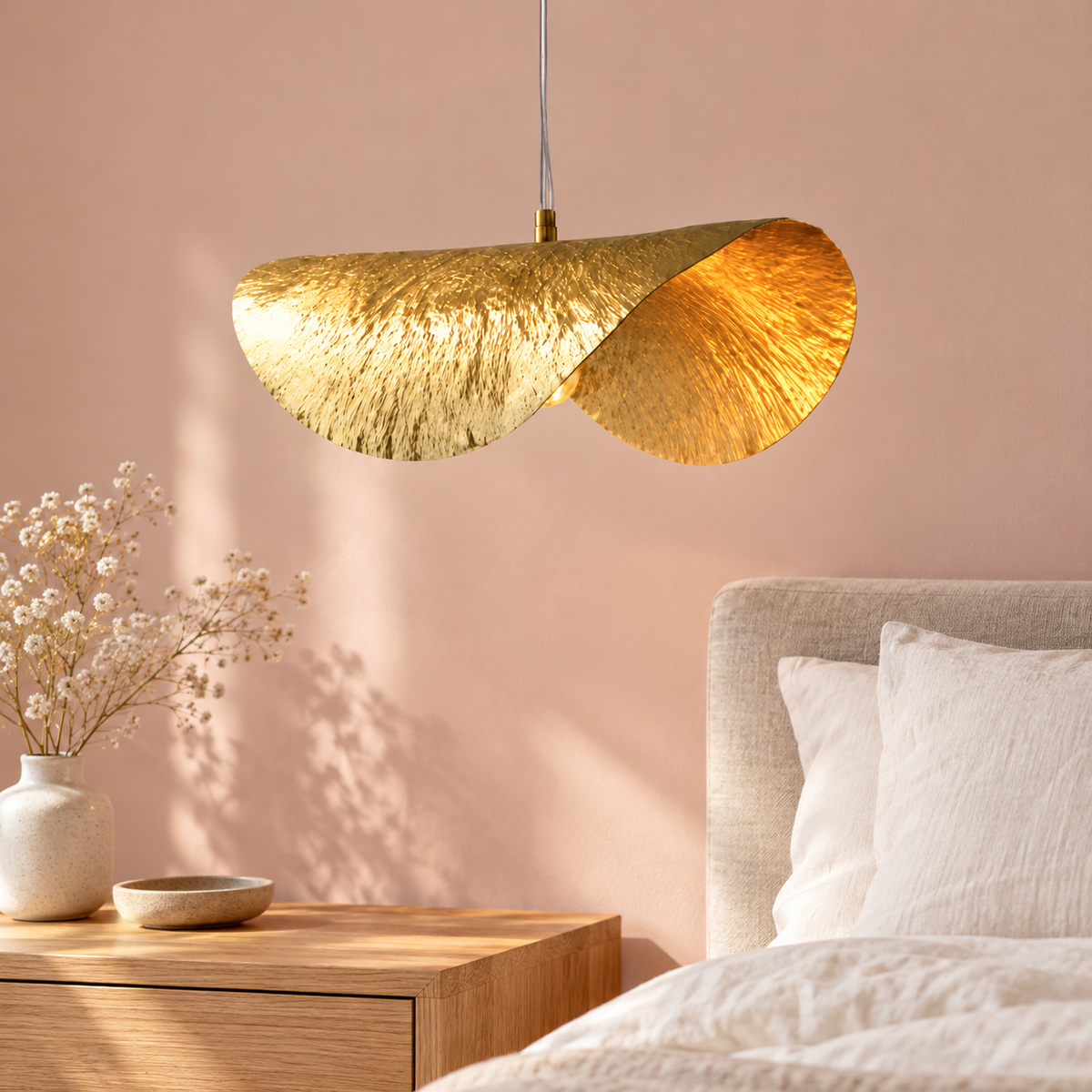 Suspension feuille de lotus dorée dans un décor illustratif au-dessus d'un chevet en chêne dans une chambre minimaliste