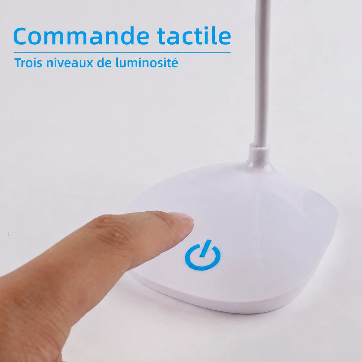 Gros plan d’un doigt près du symbole de commande sur le socle de la lampe LumaDesk.