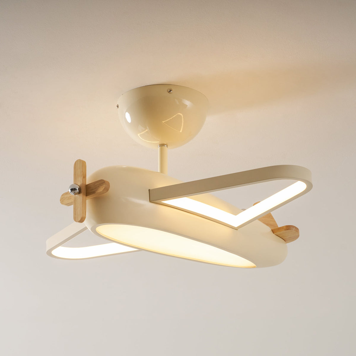 Plafonnier avion beige fixé au plafond, éclairage allumé, vue de trois quarts.