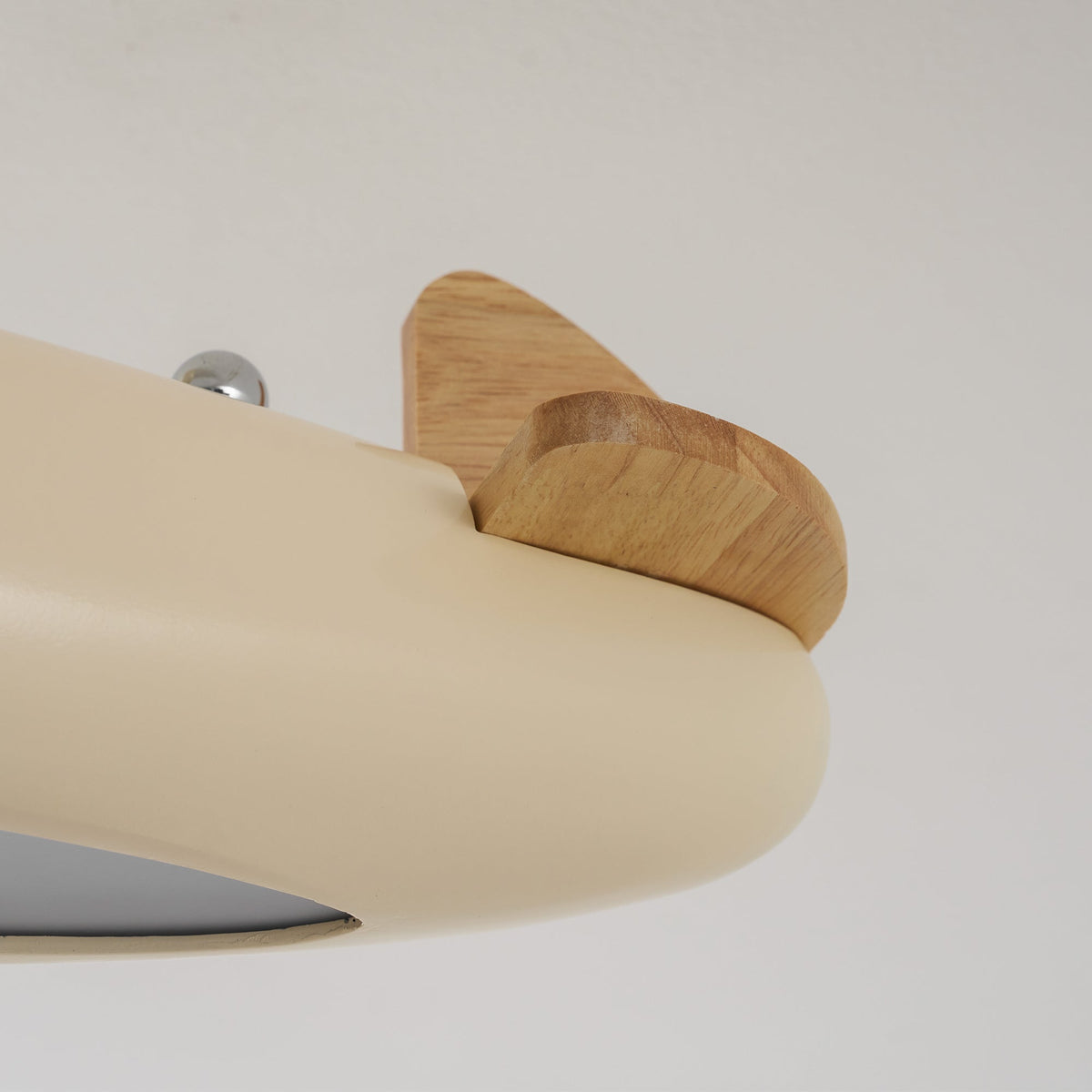 Vue rapprochée de l’empennage en bois à l’arrière du plafonnier avion beige.
