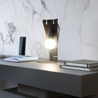 Écritoire Noir — photo fabricant sur bureau, vue de trois quarts ; ampoule et décor non inclus.