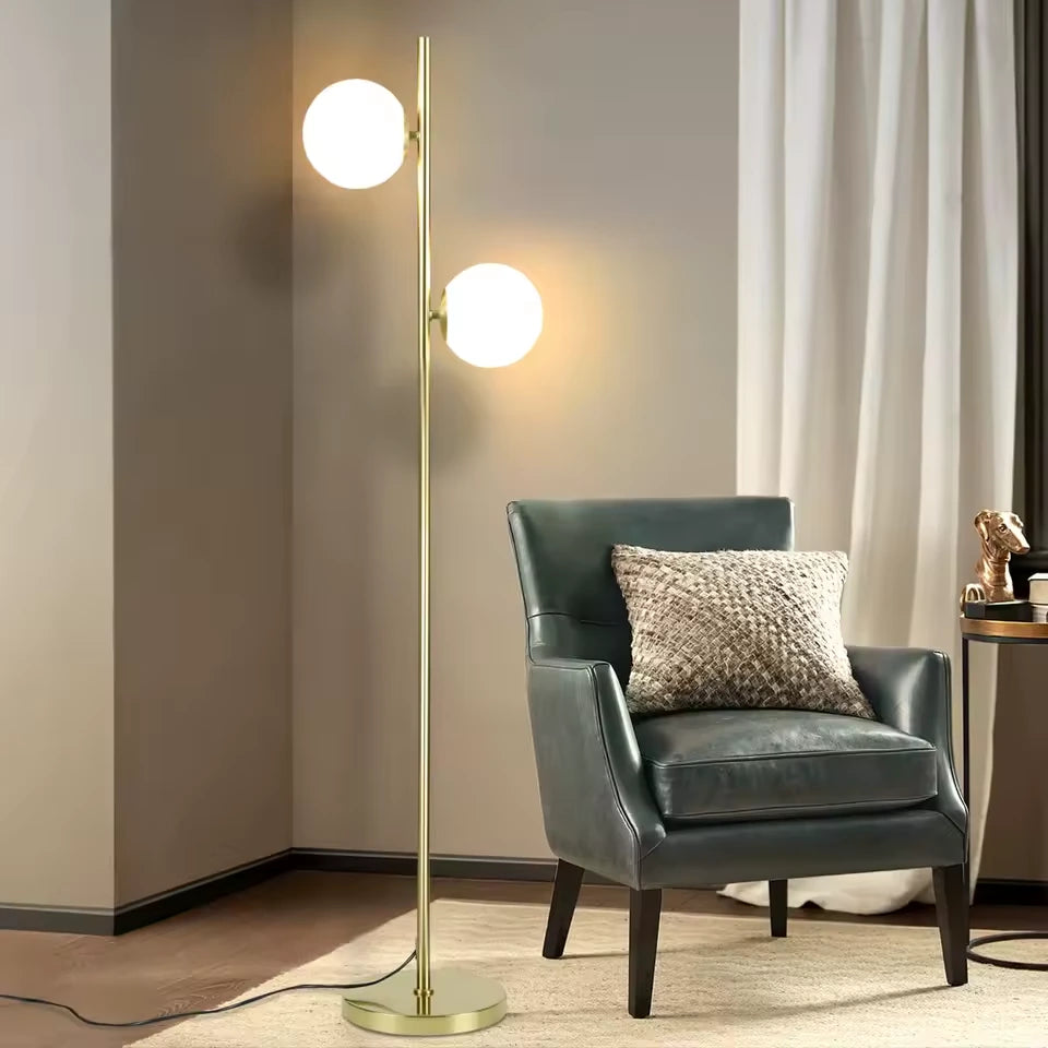 Gémelle, lampadaire doré à deux globes blancs — Éclairage près du fauteuil et des rideaux