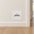 Palier blanc avec capteur — couloir, luminaire éteint. Mise en situation illustrative.