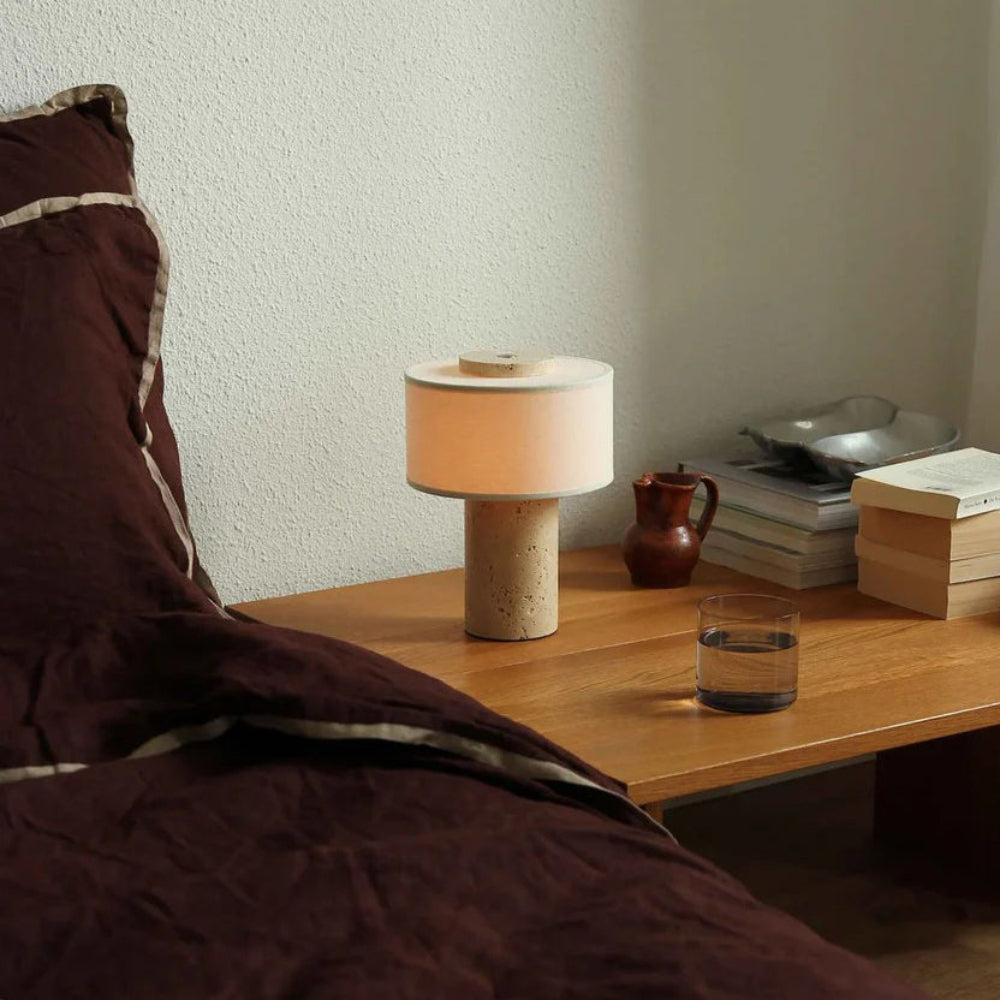 Lampe nomade en pierre — Lampe en finition beige sur une table basse, vue de trois-quarts