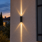 Noctéra — petite applique noire et jeu de faisceaux sur une façade