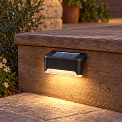 Solstice — détail d’une lampe solaire noire posée sur une marche
