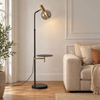 Escale — lampadaire noir et doré à tablette dans un salon