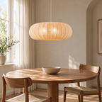 Voilure beige au-dessus d’une table ronde ; ampoules non fournies.