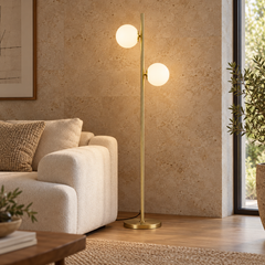 Gémelle — lampadaire doré à deux globes blancs près du canapé