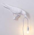 Lampe oiseau blanche portant la lumière