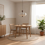 Mise en scène illustrative de la suspension Nolune blanche au-dessus d’une table ronde en bois
