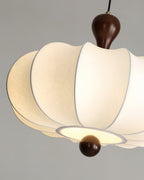 Détail du tissu blanc et du bois ton noyer de la suspension Nolune