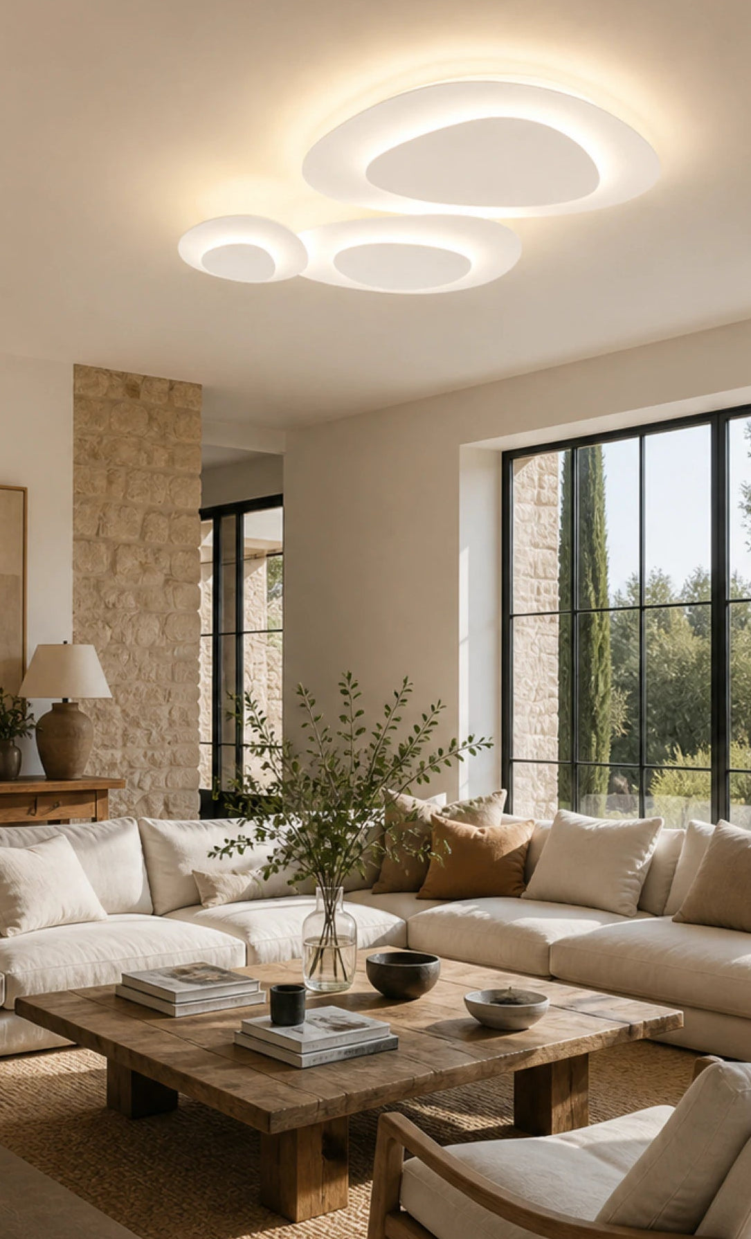 Plafonnier Nuvéa à trois éléments arrondis allumés dans un salon — illustration d’ambiance.
