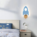 Applique Luciole en fusée bleue à flamme couleur bois près d’un lit blanc