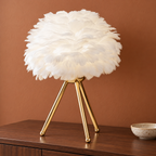 Lampe à trépied doré, abat-jour blanc sur une console terracotta — mise en scène