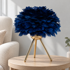 Lampe à trépied doré, abat-jour bleu près d’un fauteuil crème — mise en scène