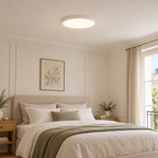 Zylo, plafonnier rond blanc à profil fin, dans une chambre aux tons naturels. Mise en scène générée ; décor non inclus.